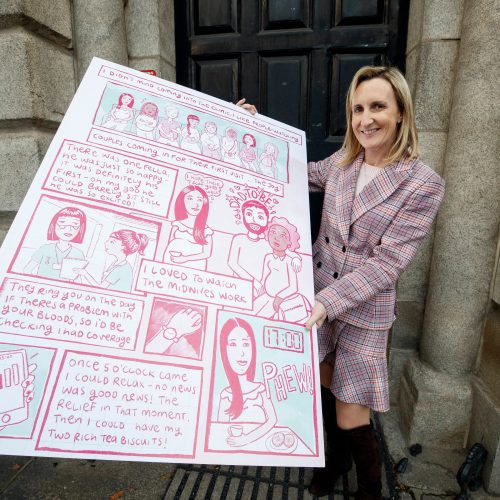 Prof. Breathnach holding a panel of the Breakfast Club comic